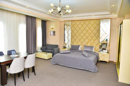 a bedroom with a bed and a table and chairs at Karat Inn Boutique Hotel in Baku