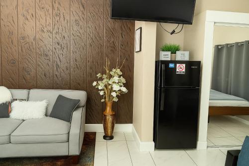 a living room with a black refrigerator and a couch at Green Castle Apartment in Tampa Near Airport and Busch Gardens in Tampa
