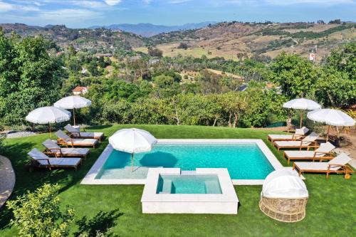 an outdoor swimming pool with chairs and umbrellas at Luxury 5 bedroom Wine Retreat Fallbrook Villa sleeps 12 in Fallbrook