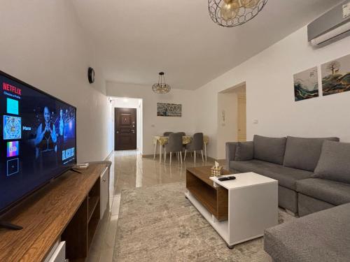 a living room with a large flat screen tv at Luxury Inn: 2BR Prime location in Madinaty B12 in Madinaty
