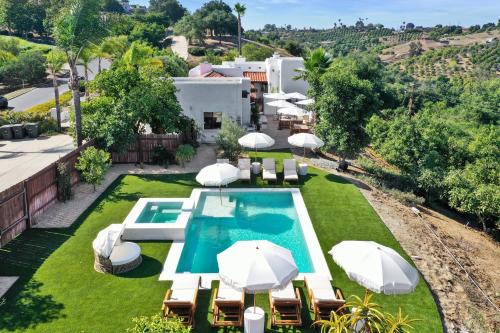 an overhead view of a pool with umbrellas and chairs at Luxury 5 bedroom Wine Retreat Fallbrook Villa sleeps 12 in Fallbrook
