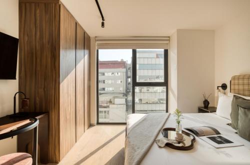 a bedroom with a bed and a large window at ULIV Pulse Roma - Condesa in Mexico City