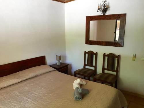 a bedroom with a bed and a mirror and two chairs at Villa Elite in Tropea
