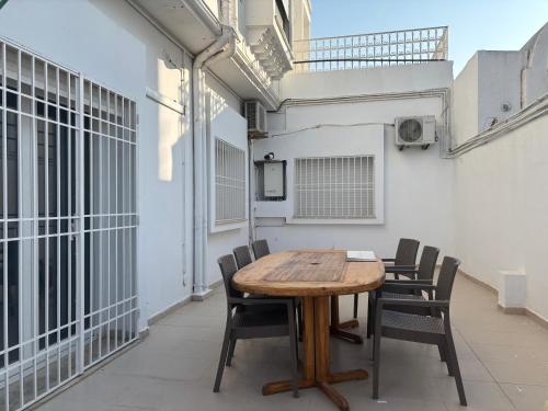 a wooden table and chairs on a balcony at Jinene logement in Yasmine