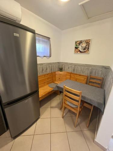 a kitchen with a stainless steel refrigerator and a table at Gréta Apartman in Ábrahámhegy