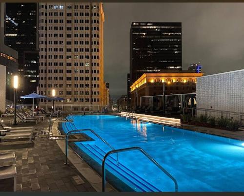 a large swimming pool in a city at night at 3-Bed High-Rise with Panoramic Views, Pool & Spa in Los Angeles