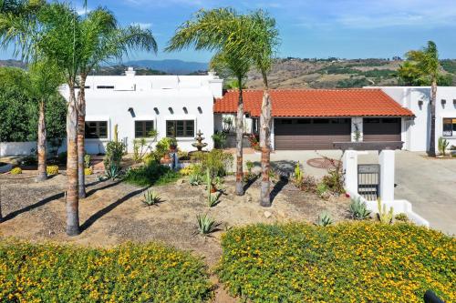 a house with palm trees in front of it at Luxury 5 bedroom Wine Retreat Fallbrook Villa sleeps 12 in Fallbrook