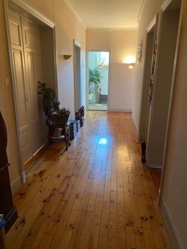 an empty hallway with a wooden floor in a house at Les chambres de Marielou in Aurillac