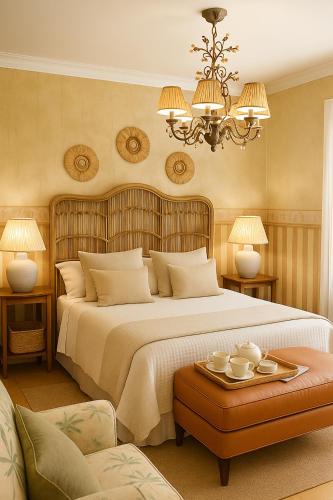 a bedroom with a large bed and a chandelier at Patxiren etxea in Bermeo