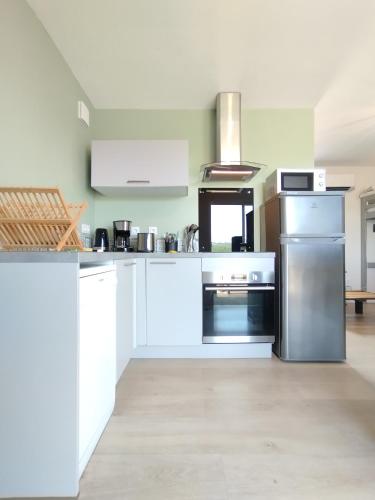 une grande cuisine avec des armoires et des appareils blancs dans l'établissement Le Rocamadour, duplex éco-conçu, 2 terrasses privatives, à Souillac