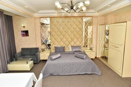 a bedroom with a large bed and a chair at Karat Inn Boutique Hotel in Baku