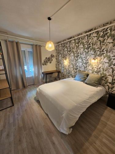 - une chambre avec un grand lit blanc et un mur dans l'établissement La Villa Milady, à Salies-du-Salat