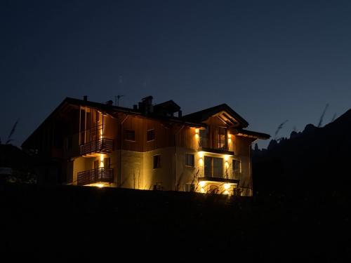 a house lit up at night with lights at Appartamento Ciclamino in Andalo