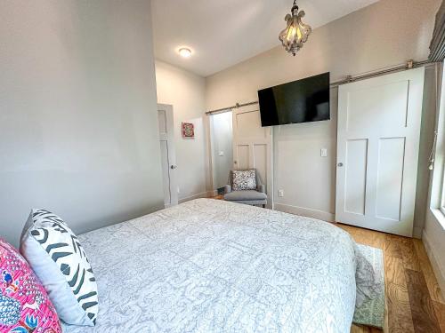 a bedroom with a bed and a flat screen tv at The 4M Favorite House - Stunning & Spotless 2-Bed Apt (#1) in Ann Arbor