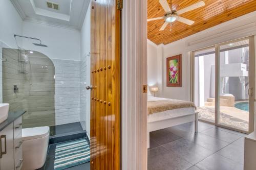 a bathroom with a shower and a bed and a ceiling fan at Castillo Colonial Nosara - by Pura Villas in Nosara