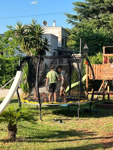 a man and a child playing on a playground at Villa don peppe in Selva di Fasano