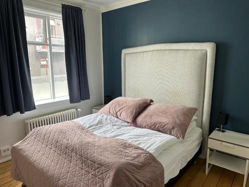 a bedroom with a bed with a blue wall at Aska Apartment in Reykjavík