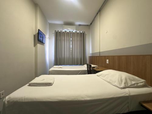 a hospital room with two beds and a window at Novo Hotel Uirapuru in Araraquara