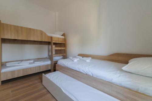 two bunk beds in a room with white sheets at House Alexandros in Asprovalta