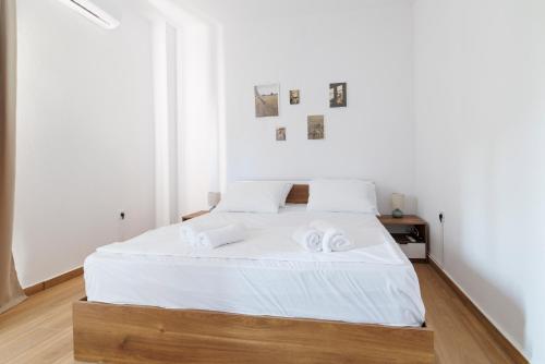 a bedroom with a bed with white sheets and towels at House Alexandros in Asprovalta