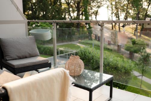 a glass coffee table with a vase on a balcony at Edison Villa 214 in Fonyód