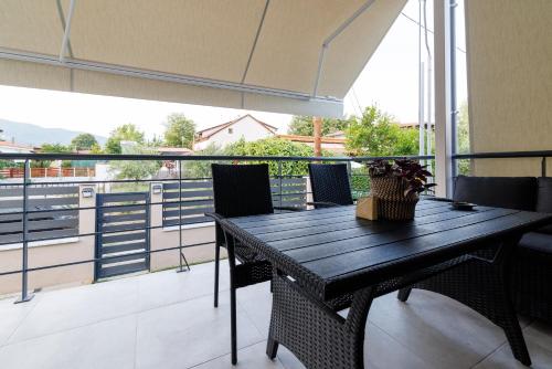 a black table and chairs on a balcony at House Alexandros in Asprovalta