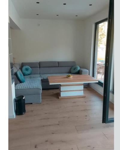 a living room with a couch and a coffee table at H&E Vikendica na vodi, Jezero Perucac 
