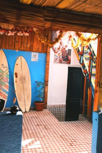 a room with two surfboards on the wall at Surfaces Hostel in Taghazout