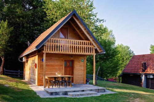 a small cabin with a table and chairs in a yard at Apartment Iko in Rakovica