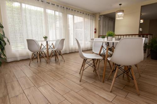 a dining room with white chairs and a table at In & Out Hotel in Guatemala