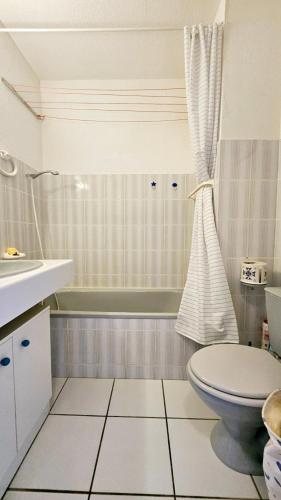 une salle de bain avec toilettes, lavabo et baignoire dans l'établissement Studio les pieds dans l'eau, à San-Nicolao