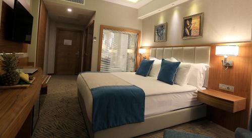 a hotel room with a large bed with blue pillows at Best Western Premier Karsiyaka Convention & Spa Hotel in Izmir