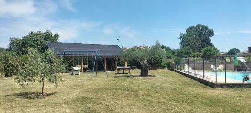 un parc avec une balançoire et une piscine dans l'établissement Mas du droulet piscine chauffée, à Laurac-en-Vivarais