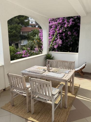 a table and two chairs on a patio with flowers at Apartments Biba Hvar in Hvar