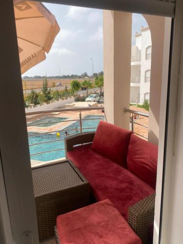 a couch on a balcony with a view of a pool at Appartement de luxe à Saidia in Saidia 