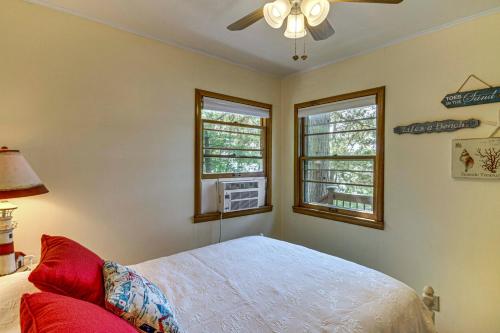 a bedroom with a bed and a fan and two windows at Family Retreat on Cross Lake Boat, Swim and Relax! in Cross Lake