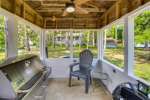 a chair sitting on a screened in porch with windows at Family Retreat on Cross Lake Boat, Swim and Relax! in Cross Lake