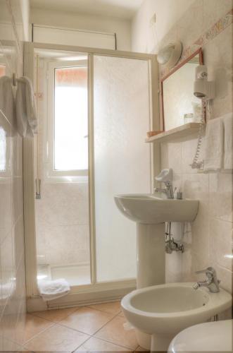 a bathroom with a toilet and a sink and a shower at Hotel Villa Lina in Loano