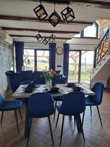 a dining room with a table and blue chairs at Orawskie wzgórze in Jabłonka
