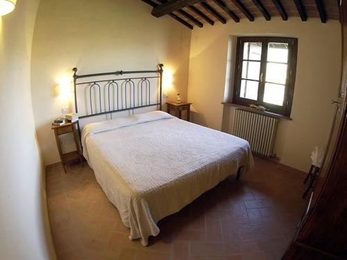 a bedroom with a large bed and a window at Agriturismo Castagna Alta in Valfabbrica