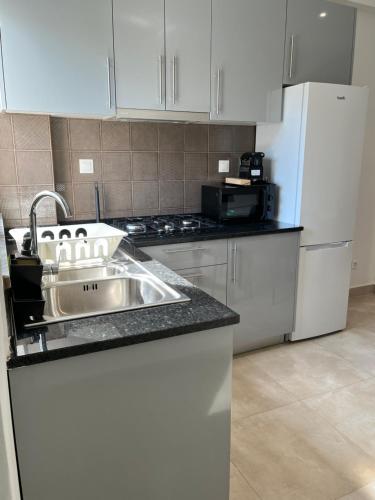 a kitchen with a sink and a refrigerator at Apartt380 in Bissau