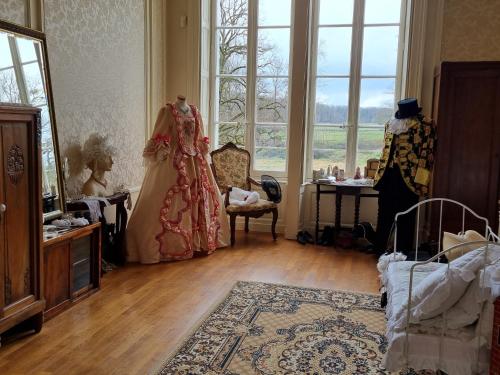 a room with a dress in a room with windows at Chateau Le Plessis in Sémelay