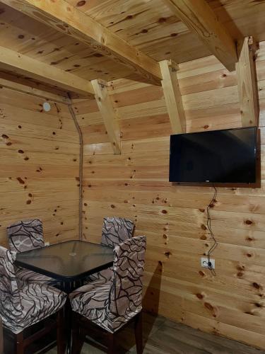 a dining room with a table and chairs and a flat screen tv at Guesthouse Stanisic in Mojkovac