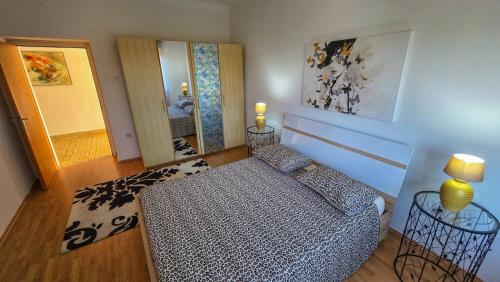 a bedroom with a bed and two mirrors at Holliday house Lidia in Brioni Maggiore