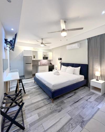 a bedroom with a large bed and a kitchen at Tapia Haus 103 - San Juan, Beach Vibes Walking Distance in San Juan