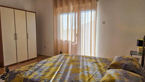 a bedroom with a bed and a large window at Holliday house Lidia in Brioni Maggiore