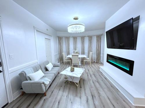 a living room with a couch and a tv on a wall at The Velvet Key near EWR airport &NYC in Newark