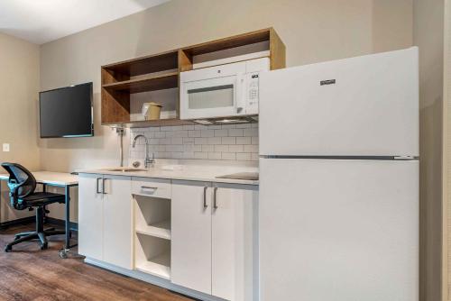 a kitchen with a white refrigerator and a microwave at Extended Stay America Premier Suites - Austin - Kyle in Kyle