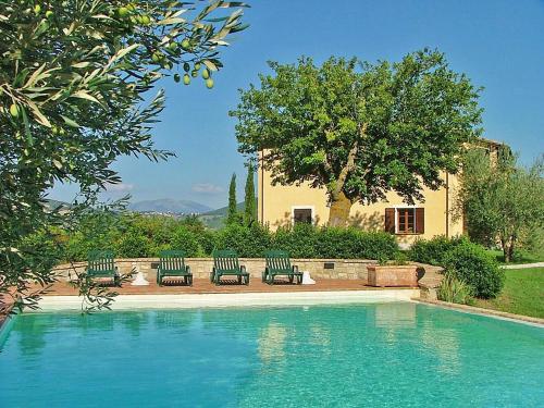 einen Pool mit vier Stühlen und ein Haus in der Unterkunft Agriturismo Castagna Alta in Valfabbrica