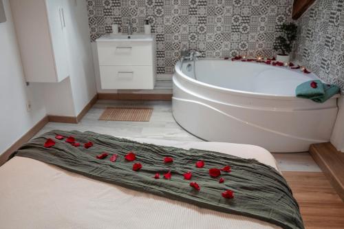 ein Badezimmer mit einem Bett mit roten Rosen darauf in der Unterkunft Le Nid vue et détente à St Etienne in Saint-Étienne